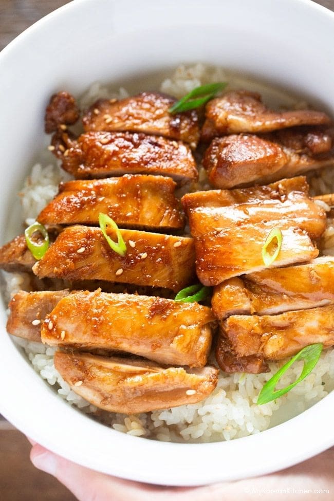 Sliced teriyaki chicken served on a bed of rice.