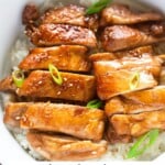 Sliced teriyaki chicken served on a bed of rice.